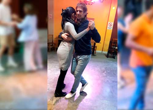 Alumnos practicando tango en pareja durante una clase